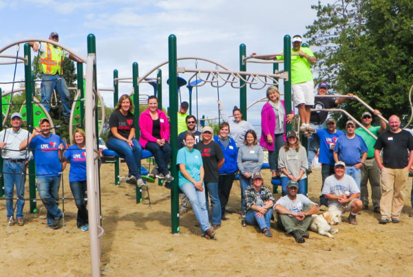 Volunteers Posing in Front of Walker Park Playground in Walker, MN