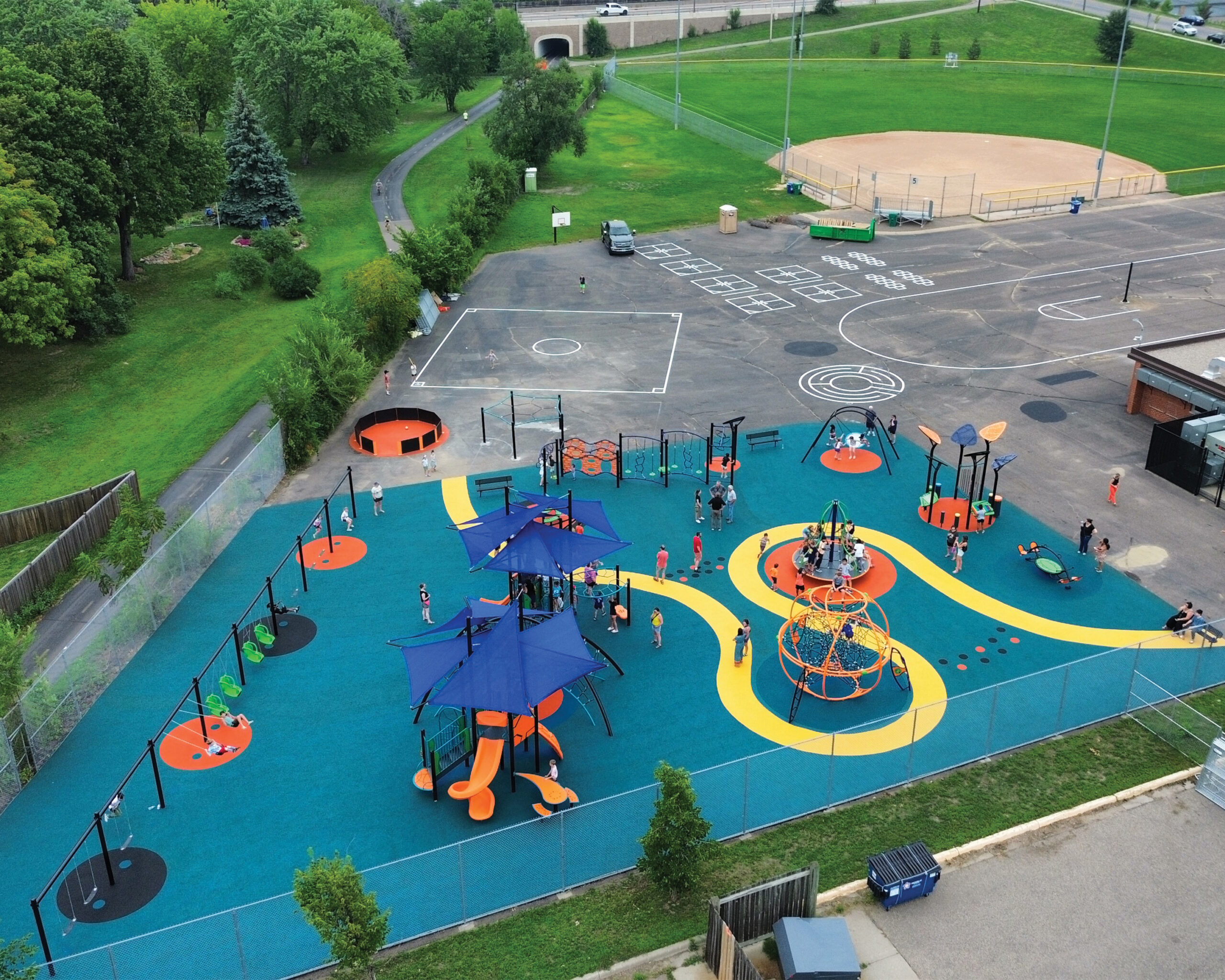 Playground at Aquila Elementary School in St. Louis Park, Minnesota featuring modern equipment and poured-in-place surfacing